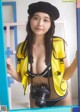 A woman in a yellow life jacket holding a camera.